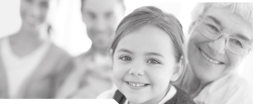 image petite fille souriante dans les bras de dame âgée souriante. Adultes en arrière-plan, heureux.